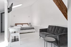 a white bedroom with a bed and a couch at White Door Apartments Mansard Heart of Odessa 2 in Odesa