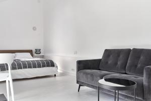a living room with a couch and a bed at White Door Apartments Mansard Heart of Odessa 2 in Odesa