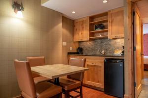 a kitchen with a table and chairs and a refrigerator at Fox Hotel and Suites in Banff