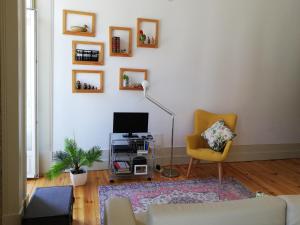 un soggiorno con divano, TV e sedia di Our Home City Flat a Porto