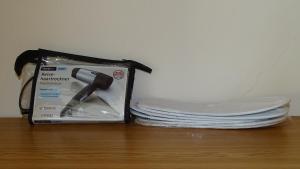 a bundle of plates and a box on a table at Hotel Elisabeta Borsh in Borsh
