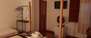 a room with a bedroom with a bed and a fan at Pousada Uai Tiradentes in Tiradentes