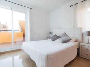 a white bedroom with a bed and a large window at Belvilla by OYO Casa Los Gallardos in Los Gallardos