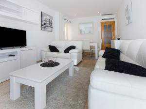 sala de estar con muebles blancos y TV en Belvilla by OYO Casa Los Gallardos, en Los Gallardos
