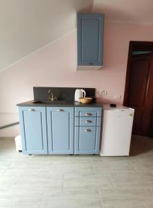a blue kitchen with a sink and a refrigerator at Regal Marine in Eforie Nord
