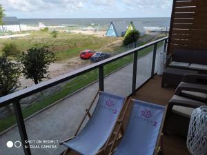 een balkon met stoelen en uitzicht op het strand bij GARDENIA Apartament Przy Plaży 17 in Dziwnów