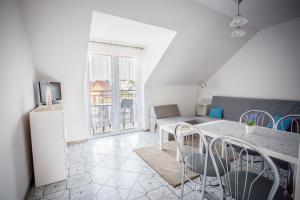 a living room with a table and chairs and a couch at Dom Gościnny Pola in Rewal