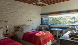 a bedroom with a bed and a table and a window at Explora en Atacama - All Inclusive in San Pedro de Atacama
