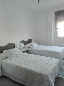 - 2 lits dans une chambre aux murs blancs dans l'établissement Apartamento Aliste, à Nerja