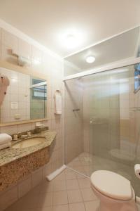 y baño con ducha, aseo y lavamanos. en Vila Olaria Hotel, en Penha