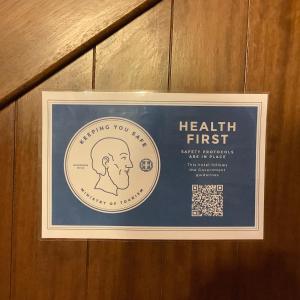 a health first sign on a wooden wall at Archontiko Riziko in Kambos