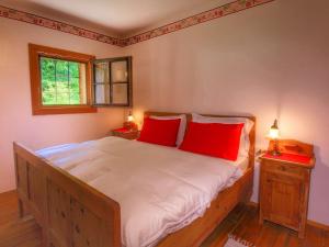 ベッラモンテにあるFascinating Cottage in Bellamonte with Saunaのベッドルーム1室(大型ベッド1台、赤い枕付)