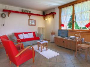 ベッラモンテにあるFascinating Cottage in Bellamonte with Saunaのリビングルーム(赤いソファ、テレビ付)