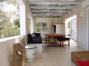 ein Wohnzimmer mit einem Tisch und einem Sofa in der Unterkunft Belvilla by OYO Casa Loma in Cala Tarida