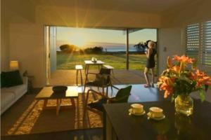 a woman standing in a living room with a view of the ocean at Ocean View Absolute Beachfront 2-Bedroom Home in Deepwater