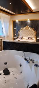 La salle de bains est pourvue d'une baignoire et d'un lit. dans l'établissement Mare Nostrum luxury suite, à Mazzeo