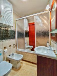 a bathroom with two sinks and a toilet in it at Apartamento con PARKING gratis en CENTRO, Merced in Huelva