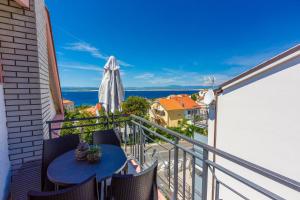a balcony with a table and an umbrella at Apartments Marijana in Crikvenica