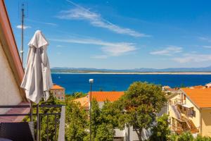 a white umbrella on a balcony with a view of the water at Apartments Marijana in Crikvenica