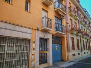 un edificio con puertas y balcones en una calle en Apartamento con PARKING gratis en CENTRO, Merced, en Huelva
