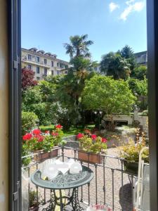 balcón con mesa y vistas al jardín en Hotel Charly en Milán