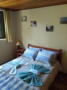 a bedroom with a bed with blue sheets and pillows at Aromas da Serra II in Campos do Jordão