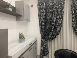 Un baño con cortina de ducha y lavabo. en B&B Siliade, en Montesilvano 20 fotos más