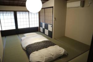 a bedroom with two beds in a room with windows at Souwaan in Takayama