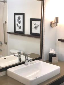 W łazience znajduje się biała umywalka i lustro. w obiekcie Country Inn & Suites by Radisson, San Jose International Airport, CA w mieście San Jose