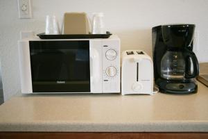 a microwave sitting on a counter next to a coffee maker at Ponderosa Motel in Goldendale