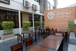 a restaurant with tables and chairs in front of a building at Serene Residence in Kanchanaburi City