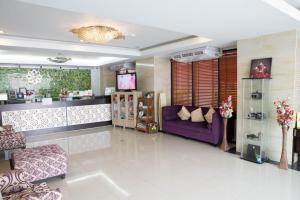 sala de estar con sofá púrpura y TV en Serene Residence, en Kanchanaburi