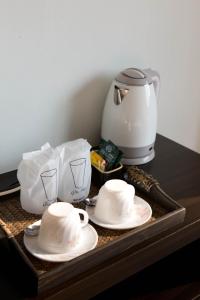 a tray with cups and plates and a coffee maker at Serene Residence in Kanchanaburi City