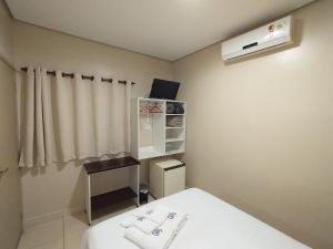 a small room with a bed and a heater at Hotel Albatroz in Uberaba
