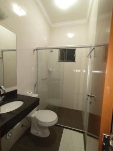 a bathroom with a toilet and a sink and a shower at Hotel Albatroz in Uberaba