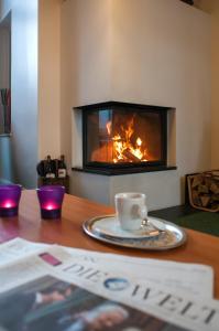 a table with a coffee cup and a fireplace at LIHO - einfach Lübeck in Lübeck