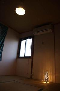 an empty room with a window and a light at Guesthouse MI CASA SU CASA in Zentsuji