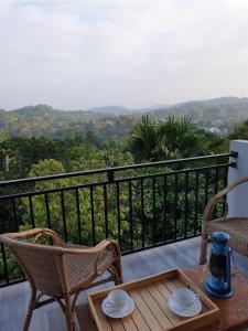 a table and chairs on a balcony with a view at Desire Village Rakwana in Rakwana