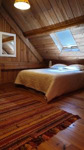 a bed in a wooden room with a window at Domaine de la Queyrie in Sarlat-la-Canéda