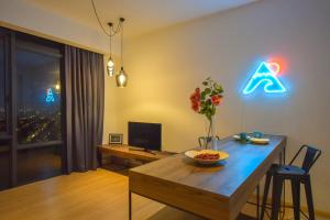 ein Wohnzimmer mit einem Esstisch und Neonschildern in der Unterkunft Cube 8teens by Nest Home in Johor Bahru