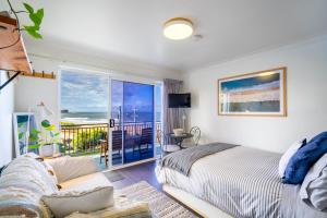 um quarto com uma cama e vista para o oceano em Sea Breeze Studio em Kiama