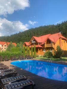 a swimming pool in front of a house at Котедж "Villa Затишна" in Mykulychyn