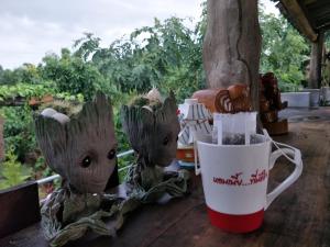 a table with a coffee cup and a couple of baby groot cups at Teak villa in Thoeng