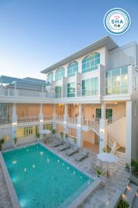 an image of the front of a hotel with a swimming pool at De Hug Hotel & Residence in Chiang Rai