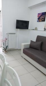 - un salon avec un canapé et une télévision murale dans l'établissement Relais DiVi, à Castellammare di Stabia