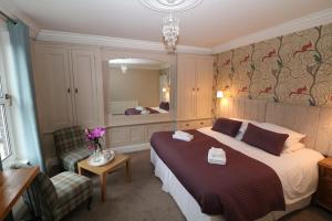 Habitación de hotel con cama grande y espejo en Four Seasons Guesthouse, en Castleton