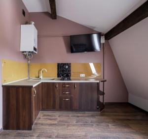 a kitchen with a sink and a tv on the wall at Apartment on Lychakivska in Lviv