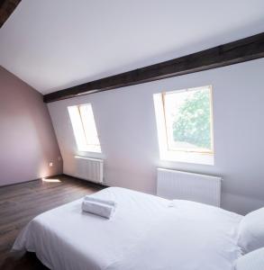 a bedroom with a white bed and two windows at Apartment on Lychakivska in Lviv