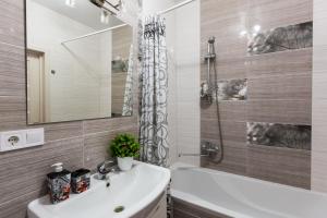 a bathroom with a sink and a tub and a mirror at Новобудова Леви Міста Стрийська Наукова Володимира Великого Сихів in Lviv