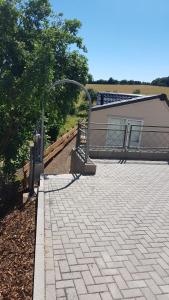 a brick patio with a building in the background at Ferienhaus Chilllout Chalets Daun-Kradenbach in Kradenbach